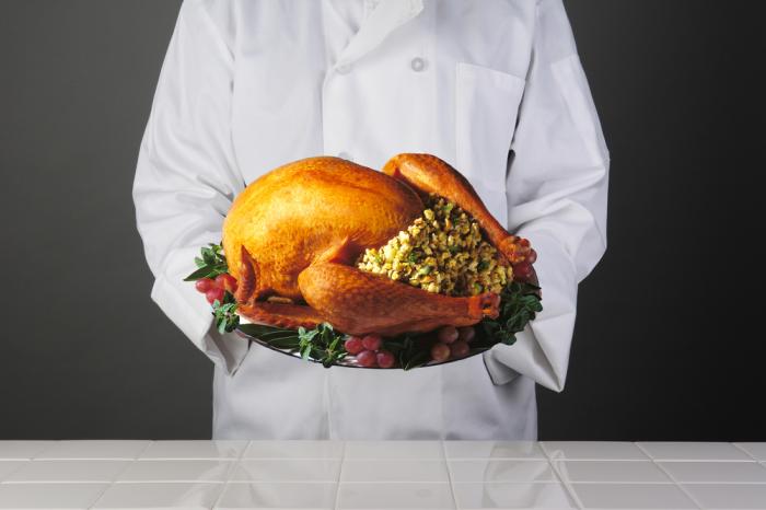 Chef holding stuffed turkey on a plate